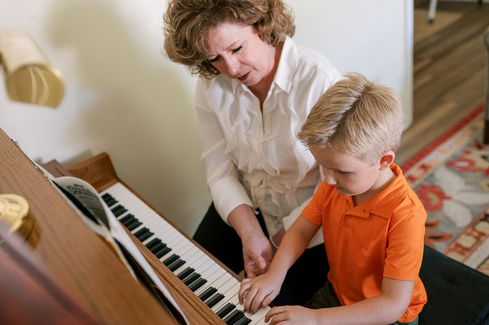 Amy and a young boy playing the piano